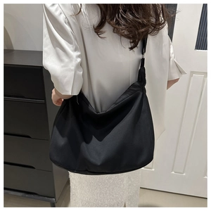 Detail of the high-quality black nylon shoulder bag shown worn by a model