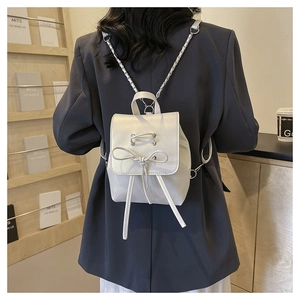 Mini white PU leather backpack featuring bow tie detail and metallic chain straps