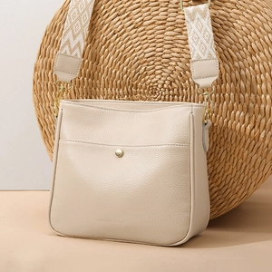 Creamy white lychee pattern crossbody bag with wide geometric woven shoulder strap