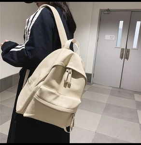 Close-up of cream white PU leather backpack with pebble texture and front zipper