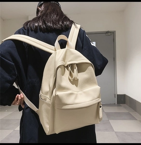 Detail view of cream PU leather backpack featuring litchi texture and multiple pockets
