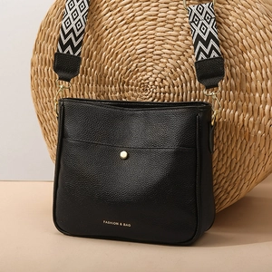 Fashionable black pebbled leather crossbody bag with geometric pattern wide strap