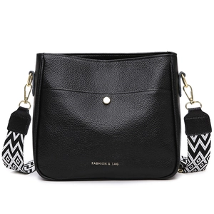 Fashionable black pebbled leather crossbody bag with geometric woven strap on white background