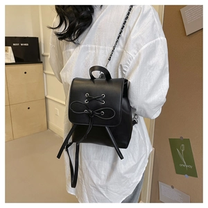Detail showing back view of black PU leather backpack with bow-knot and chain strap