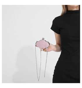 Pink sequin cloud-shaped mini evening bag with silver chain worn by a model