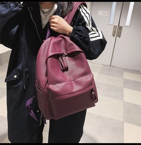 Detail of purple lychee textured leather backpack with large front zip pocket