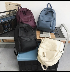Minimalist waterproof PU leather backpacks shown in purple, blue, black and cream colors