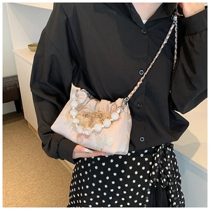 Détail du sac bandoulière en soie à broderie florale rose avec poignée en perles et chaîne
