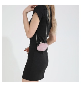 Pink glitter cloud clutch bag with silver chain strap shown on black dress model