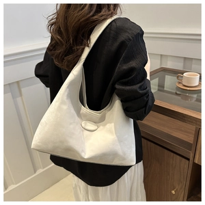 White minimalist PU leather Hobo bag shown on model in a modern indoor lifestyle setting