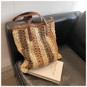 Fashionable large woven straw tote bag with brown leather handles and striped design