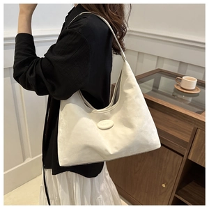 Off-white faux leather hobo bag with oval hardware detail shown in a lifestyle setting