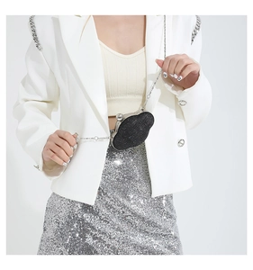 Close-up of black glitter cloud crossbody bag with silver chain and sphere clasp