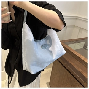 Detail of light blue satin hobo bag featuring silk texture and oval logo plaque