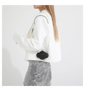 Detail of black sequin cloud crossbody bag with silver chain strap on model