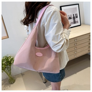 Detail of a pink crescent-shaped hobo bag in matte nylon with leather strap