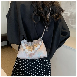 Détail du sac bandoulière en soie rose à fleurs avec poignée en perles et chaîne argent