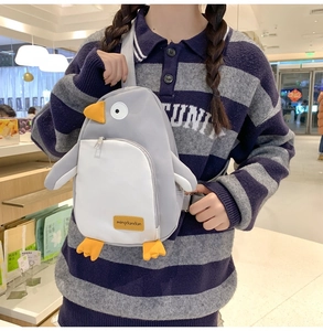 Detailansicht einer süßen grauen Pinguin-Umhängetasche aus Nylon an einem Model