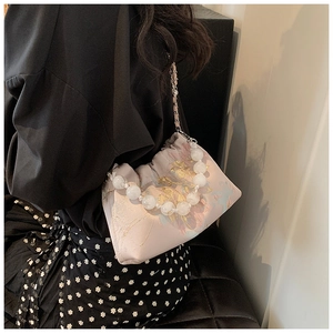 Détail du sac bandoulière en soie avec imprimé fleuri, poignée en perles et chaîne