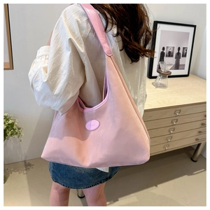 Detail view of pink large capacity nylon hobo shoulder bag with wide leather strap
