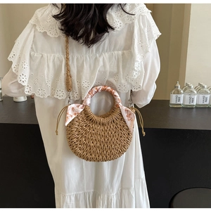 Detailed back view of a woven crescent bag with floral scarf handle and shoulder strap