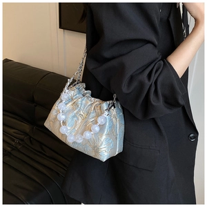 Détail du sac nuage en jacquard fleuri bleu et or avec poignée en perles et chaîne