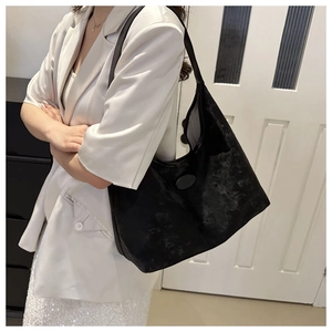 Fashionable black PU leather tote bag shown on a model in a stylish outfit