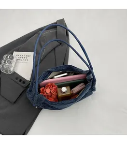Spacious interior of denim chain tote bag showing room for umbrella and notebook