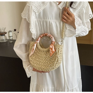 Detail of woven straw crossbody bag with floral scarf handle and drawstring lining