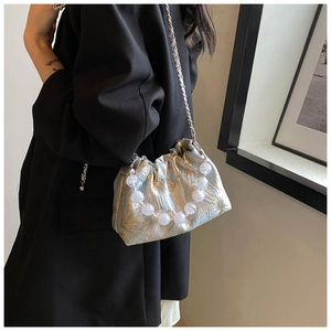 Détail du sac nuage en soie jacquard florale avec poignée perle et chaîne argent