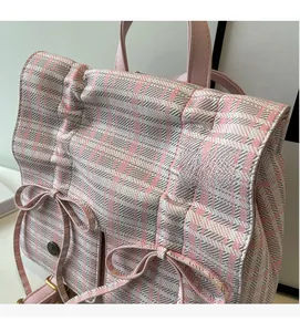 Close-up of pink and white checkered tweed fabric with decorative satin bows