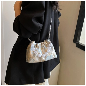 Détail du sac bandoulière en soie avec poignée en perles et tissu jacquard métallique