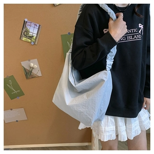 Detail of light blue nylon crossbody bag featuring stylish pleated cloud shoulder strap