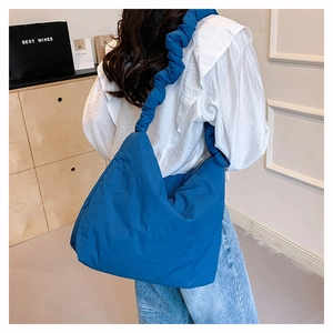 Détail du sac bandoulière en nylon matelassé bleu avec bandoulière plissée froncée