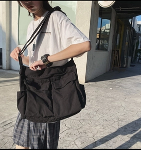 Detail shot of black canvas crossbody bag with large utility pockets in streetwear style