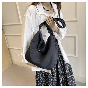 Close-up of black nylon crossbody hobo bag showing fabric texture and wide strap