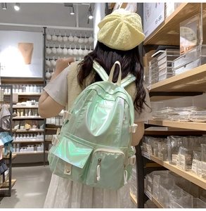 Detail view of holograph laser mint green backpack showing multi-pocket design and buckles