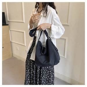 Detail of the black nylon hobo bag featuring a unique ruffled shoulder strap design