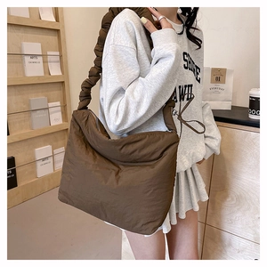 Détail du sac bandoulière en nylon marron avec bandoulière plissée style nuage