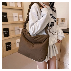 Détail d'un grand sac cabas en nylon marron avec tissu matelassé et larges bandoulières