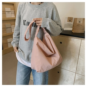 Detail of light pink nylon tote bag showing spacious design and soft wrinkled texture