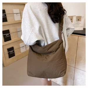 Détail de la bandoulière réglable et de la boucle sur le sac en nylon marron foncé