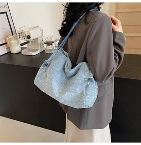 Detailed close-up of light blue denim tote bag with drawstring and soft slouchy texture
