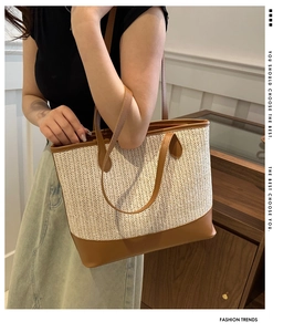 Detail of woven straw tote bag featuring brown leather trim and sturdy dual handles
