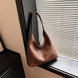 Fashionable woven caramel brown hobo tote bag with a minimalist shoulder strap design