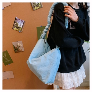Détail du sac matelassé en nylon bleu ciel avec bandoulière froncée au design unique