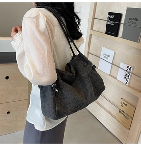 Detailed shot of dark grey denim tote bag showing fabric texture and knot drawstring detail