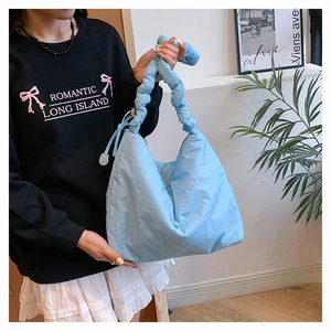 Détail du sac bandoulière bouffant en nylon bleu clair avec bandoulière nouée chic