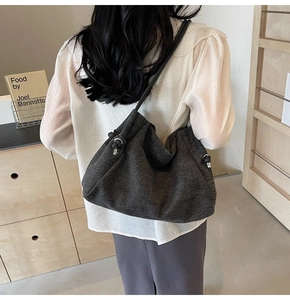 Detailed view of grey denim fabric tote bag with elegant knot detail on shoulder strap