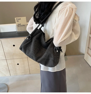 Detailed view of dark grey fabric tote bag with textured grain and silver buckle detail